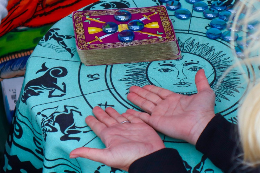Mujer con las palmas hacia arriba y cartas de tarot